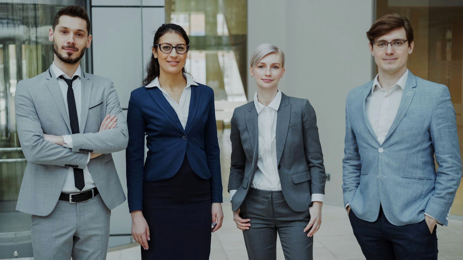 Four coworkers standing together in a bright office, the size of a typical Missouri small group